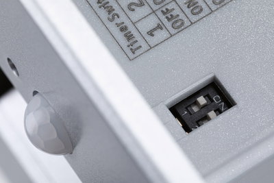 Nahaufnahme eines grauen Kunststoffgehäuses mit DIP-Schalter und Sensor für Lichtsteuerung