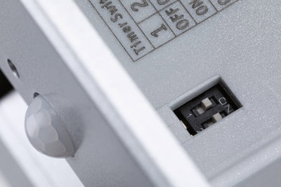 Gros plan d’un boîtier en plastique gris avec interrupteur DIP et capteur pour contrôle lumineux