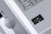 Close-up of grey plastic housing with DIP switch and sensor for light control
