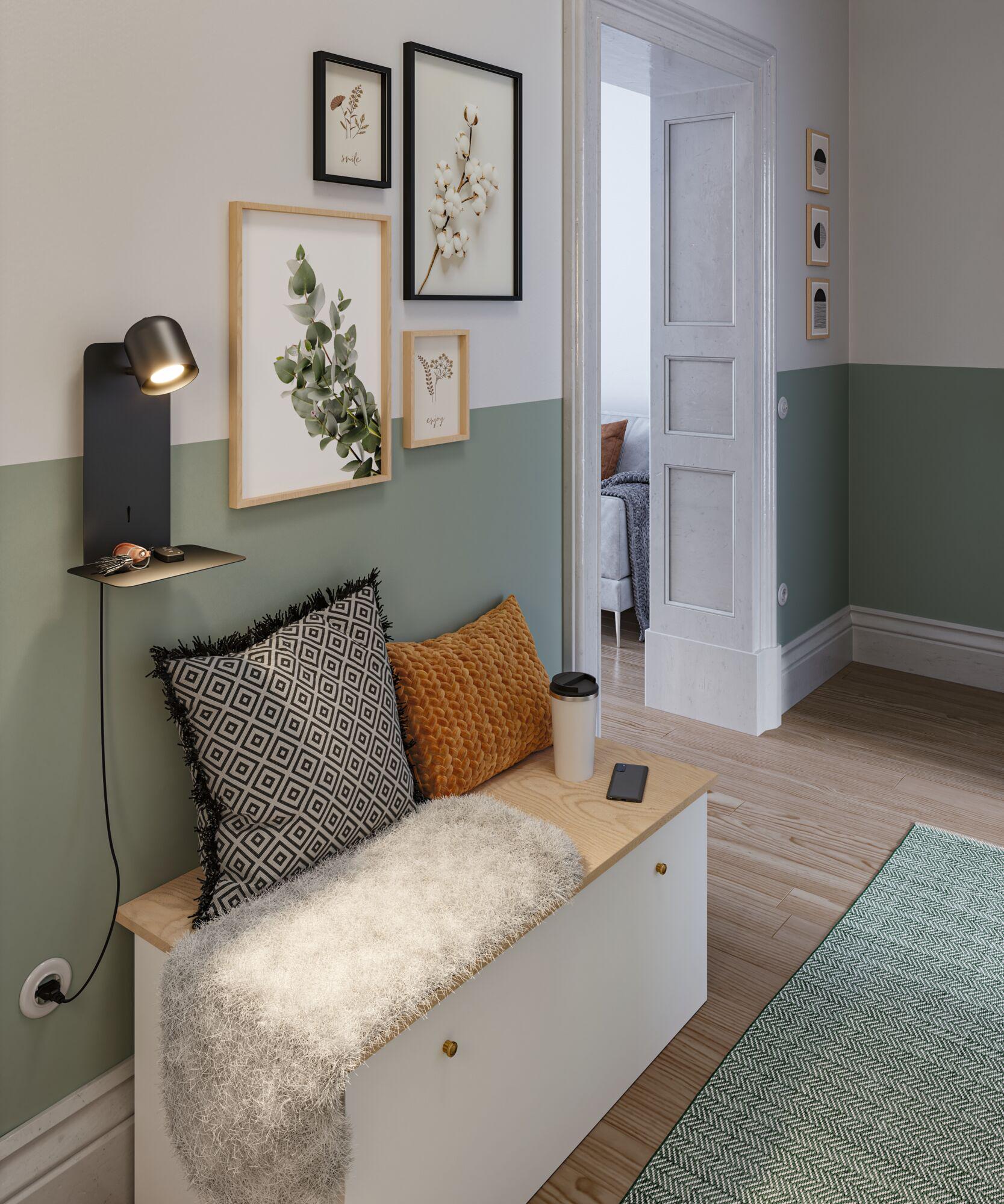 Schwarze Wandlampe mit Ablage aus Metall an grün-weißer Wand über Sitzbank mit Kissen und Decke