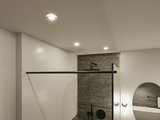 Modern bathroom with black fixtures and grey stone wall, illuminated by three recessed ceiling lights