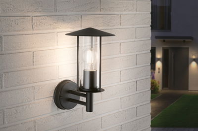Black metal outdoor wall light with clear glass and visible LED bulb for garden lighting.