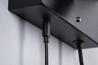 Schwarzes Kabel mit Stecker an mattschwarzem Metallgehäuse für LED-Beleuchtungssysteme.