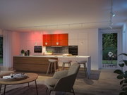 Modern kitchen with wooden island, white pendant lights and LED ceiling spotlights for ambient lighting