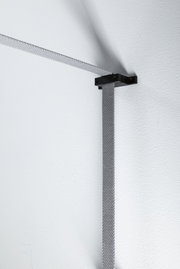 Grauer textiler Kabelhalter aus Metall an weißer Wand für moderne Beleuchtungssysteme