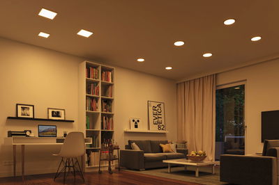 Moderne woonkamer met warmwitte LED-plafondlampen en gezellige bruine en beige inrichting
