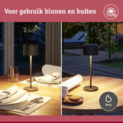 Zwarte tafellamp met metalen voet op houten tafel, geschikt voor binnen- en buitengebruik met IP44 bescherming