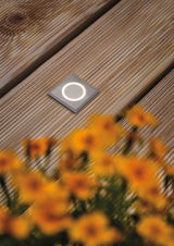 Quadratischer Edelstahl-LED-Bodeneinbaustrahler mit warmweißem Licht auf Holzterrasse für Außenbeleuchtung