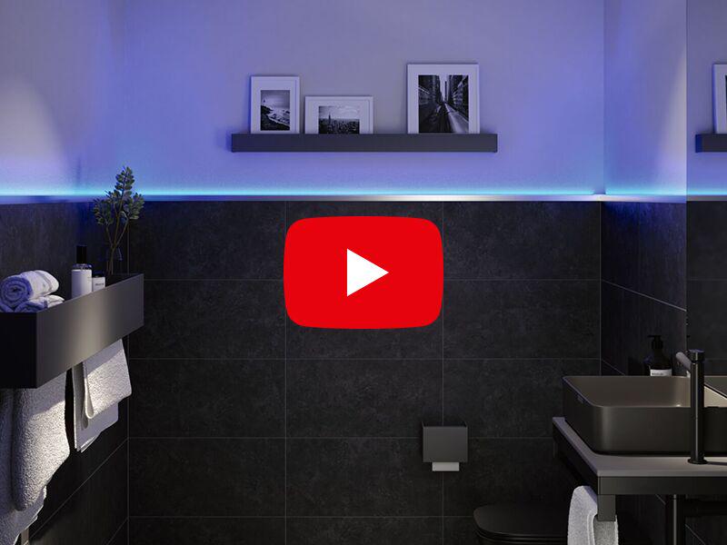 Salle de bain moderne avec carrelage noir et bande LED bleue pour un éclairage d'ambiance