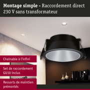 Spot encastré noir avec réflecteur argenté au plafond blanc dans un salon moderne