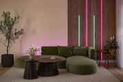 Modernes Wohnzimmer mit grünem Stoffsofa, Holz-Couchtischen und LED-Streifenbeleuchtung in Pink und Blau