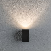Schwarze LED-Wandleuchte aus Metall mit warmweißem Licht an strukturierter grauer Wand