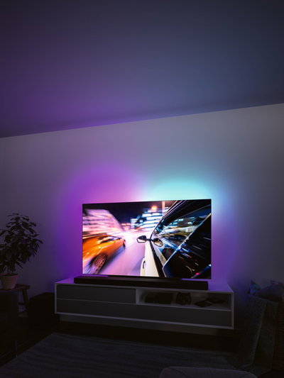 Modern living room with TV and colorful LED backlight creating ambient lighting effect