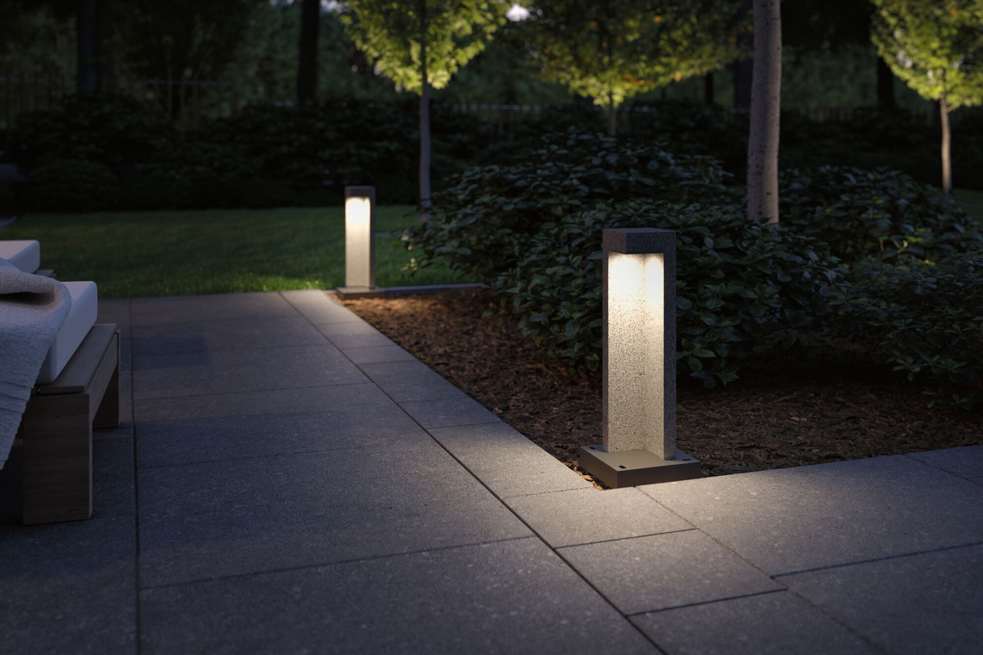 Moderne grijze stenen buitenlampen op terras verlichten tuinpad 's nachts voor buitenverlichting
