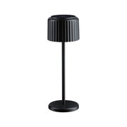 Black metal table lamp with ribbed shade and round base for modern interior lighting