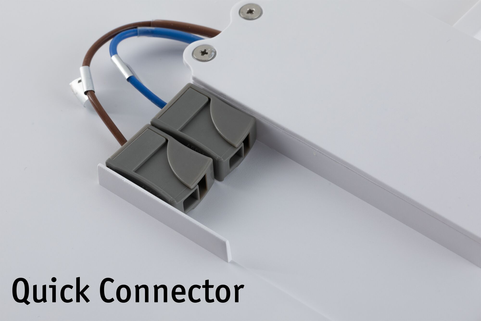 Gray plastic quick connector with brown and blue wires attached to white LED panel for lighting setup.