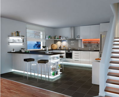 Cuisine blanche moderne avec éclairage LED sous les meubles et sur les escaliers pour une ambiance élégante.