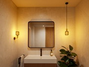 Modern bathroom with square mirror, white sink, and warm LED wall and pendant light in metal design.