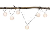 String lights with white round plastic lanterns hanging on a branch for cozy decoration.