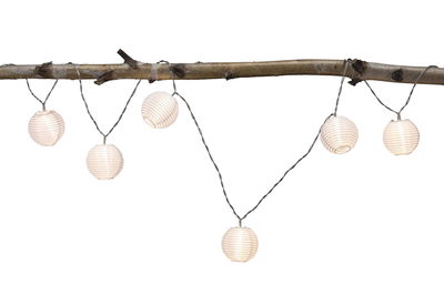 String lights with white round plastic lanterns hanging on a branch for cozy decoration.