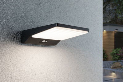 Schwarze LED-Außenwandleuchte mit Bewegungsmelder an grauer Wand für Gartenbeleuchtung