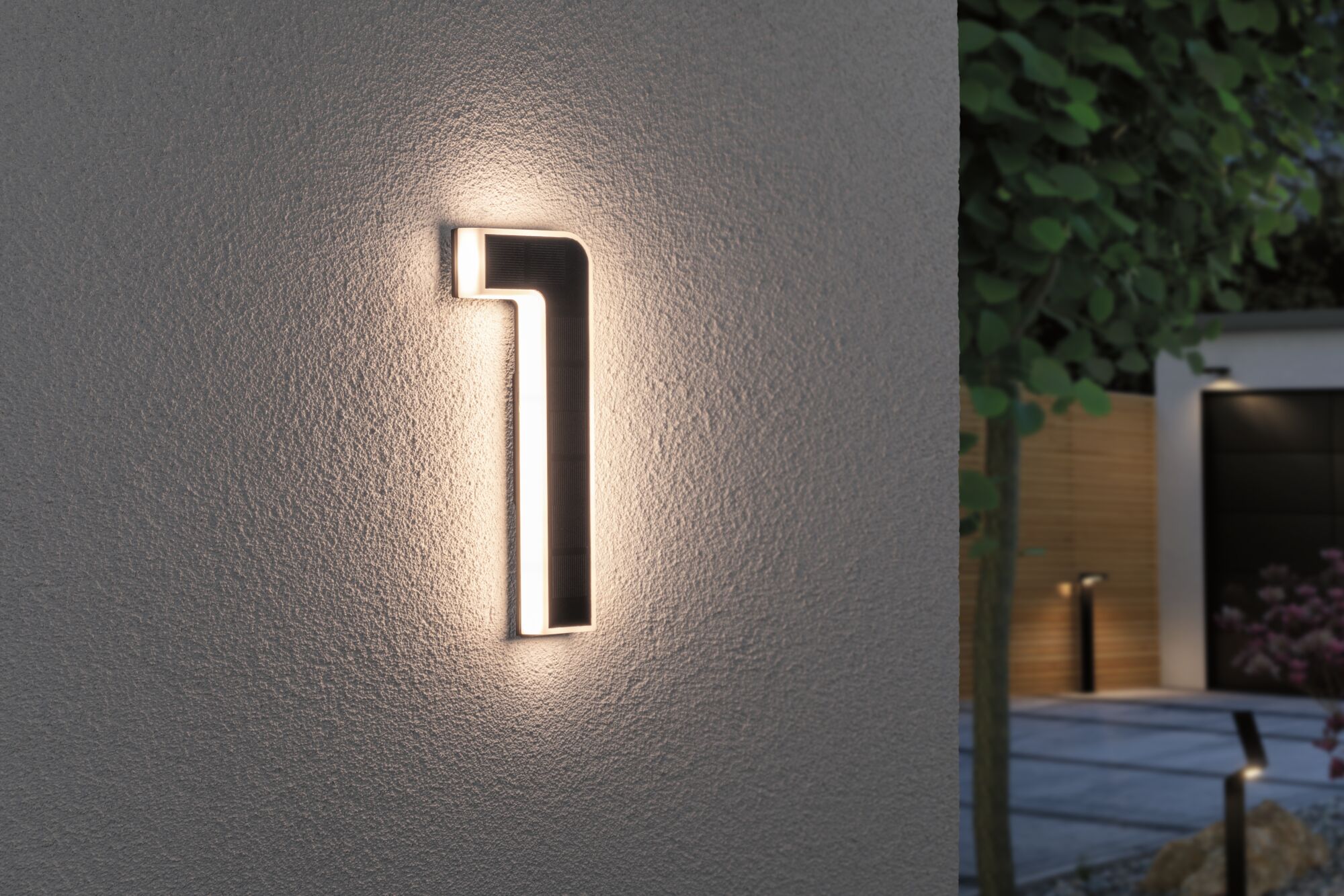 Modern black LED wall light with warm white glow on exterior wall for garden lighting