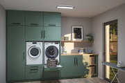 Buanderie moderne verte intégrée avec machine à laver, sèche-linge et panier à linge dans pièce lumineuse