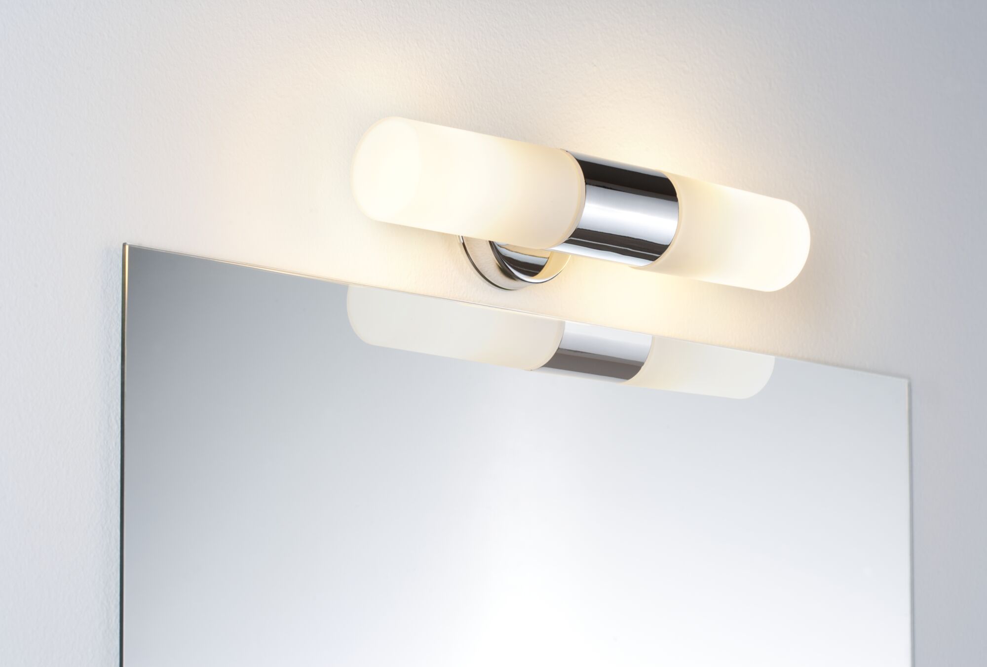 Moderne Wandlampe mit mattweißem Glas und Chromhalterung über Spiegel für Badezimmerbeleuchtung