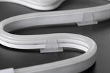 Flexible white LED neon light with transparent clip on dark surface for decorative lighting solutions