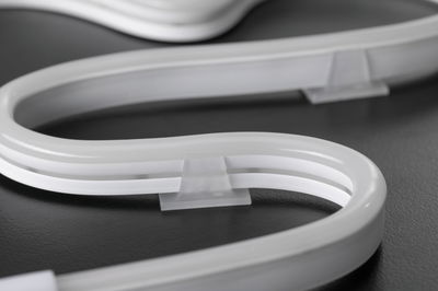 Flexibles weißes LED-Neonlicht mit transparenter Halterung auf dunklem Untergrund für dekorative Beleuchtung