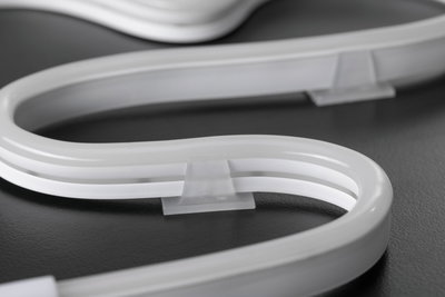 Flexibles weißes LED-Neonlicht mit transparenter Halterung auf dunklem Untergrund für dekorative Beleuchtung