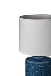 Table lamp with white fabric shade and blue ceramic base featuring shell pattern for home lighting