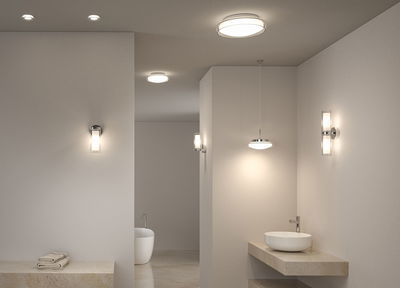 Modern bathroom with white glass and metal wall and ceiling lights providing stylish illumination