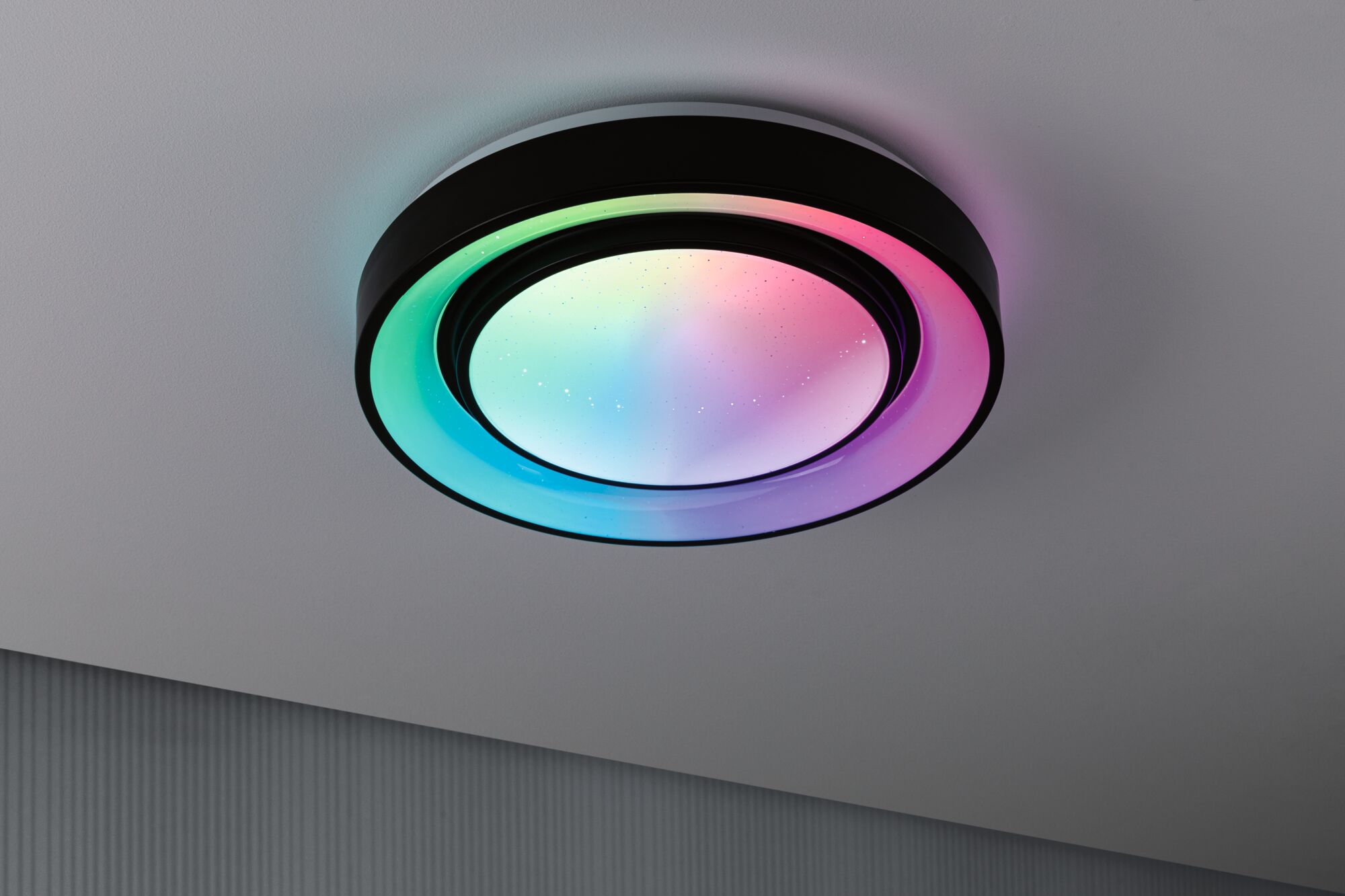 Round LED ceiling light with black frame and multicolor illumination for modern interiors.