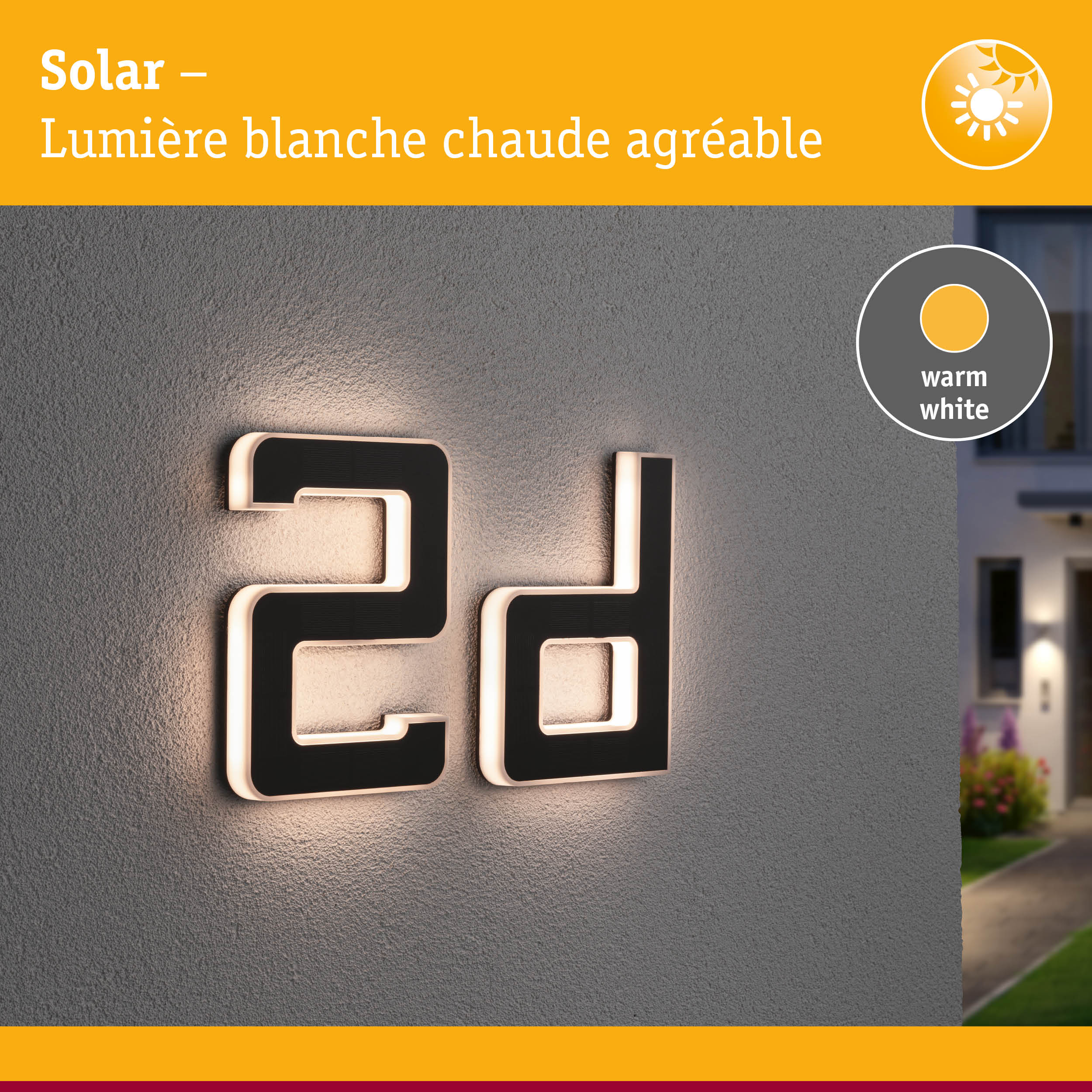 Numéro de maison solaire en matériau noir avec lumière LED blanc chaud sur mur gris