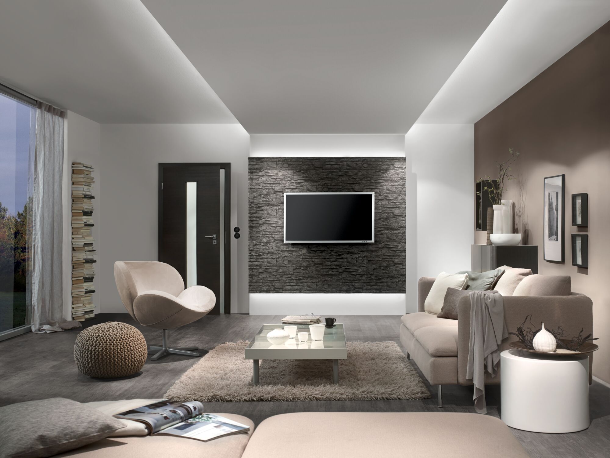 Modernes Wohnzimmer mit indirekter LED-Deckenbeleuchtung und grauer Steinwand für stilvolle Raumbeleuchtung