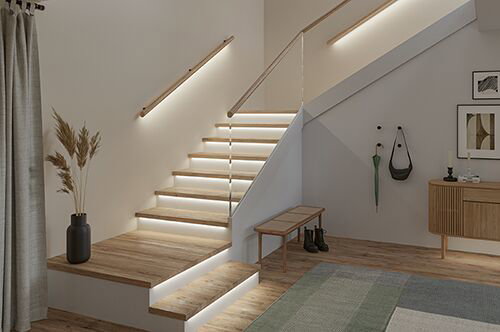 Modern staircase with LED step lighting and wooden steps in bright living space with glass railing
