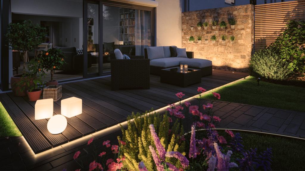Terrasse en soirée avec éclairage LED moderne sur terrasse en bois et plantes décoratives.