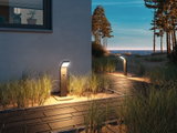 Modern anthracite metal LED path light with motion sensor on beach walkway at dusk for outdoor lighting.