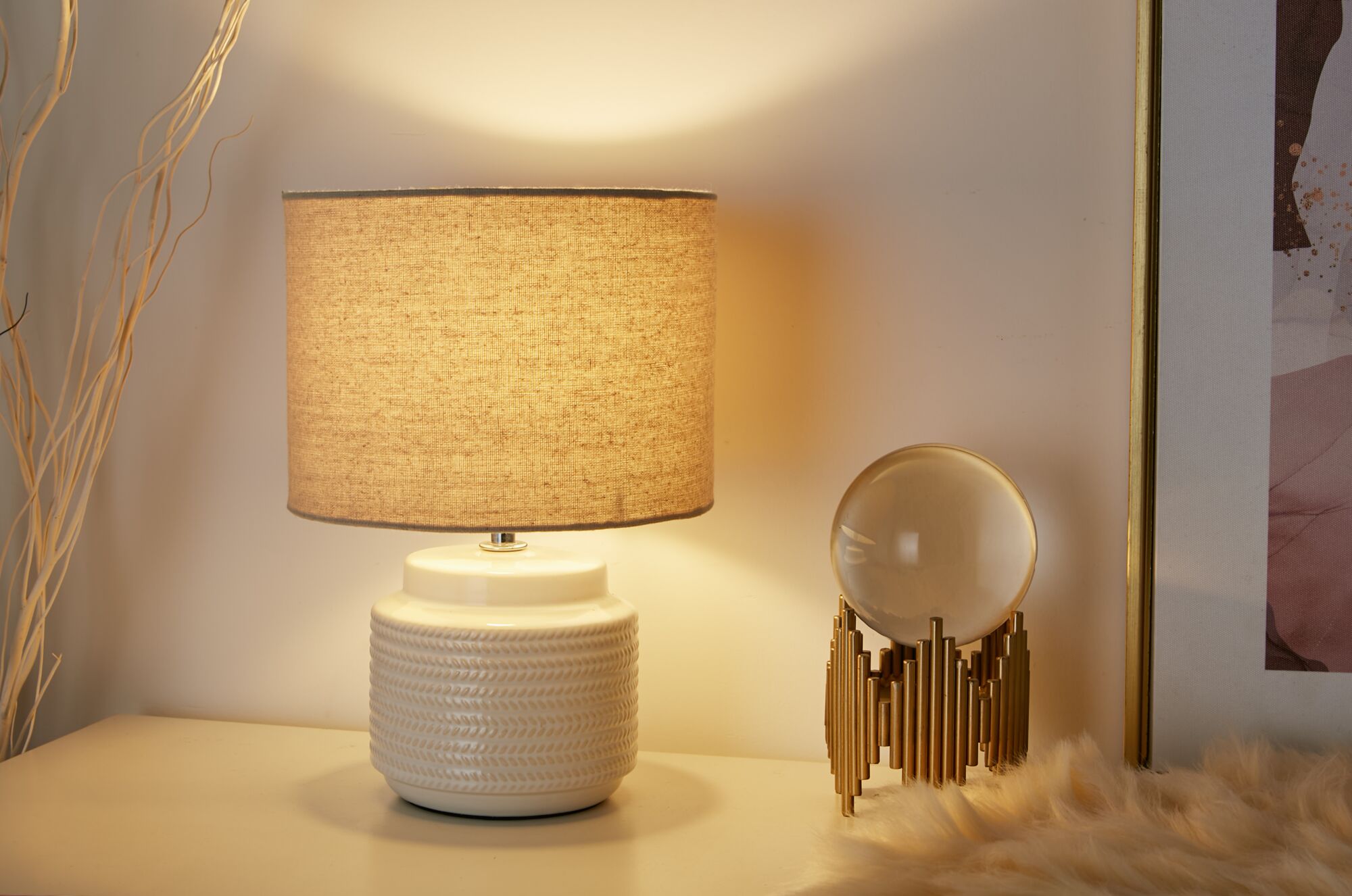 Lampe de table avec base en céramique crème et abat-jour en tissu beige pour une ambiance chaleureuse.