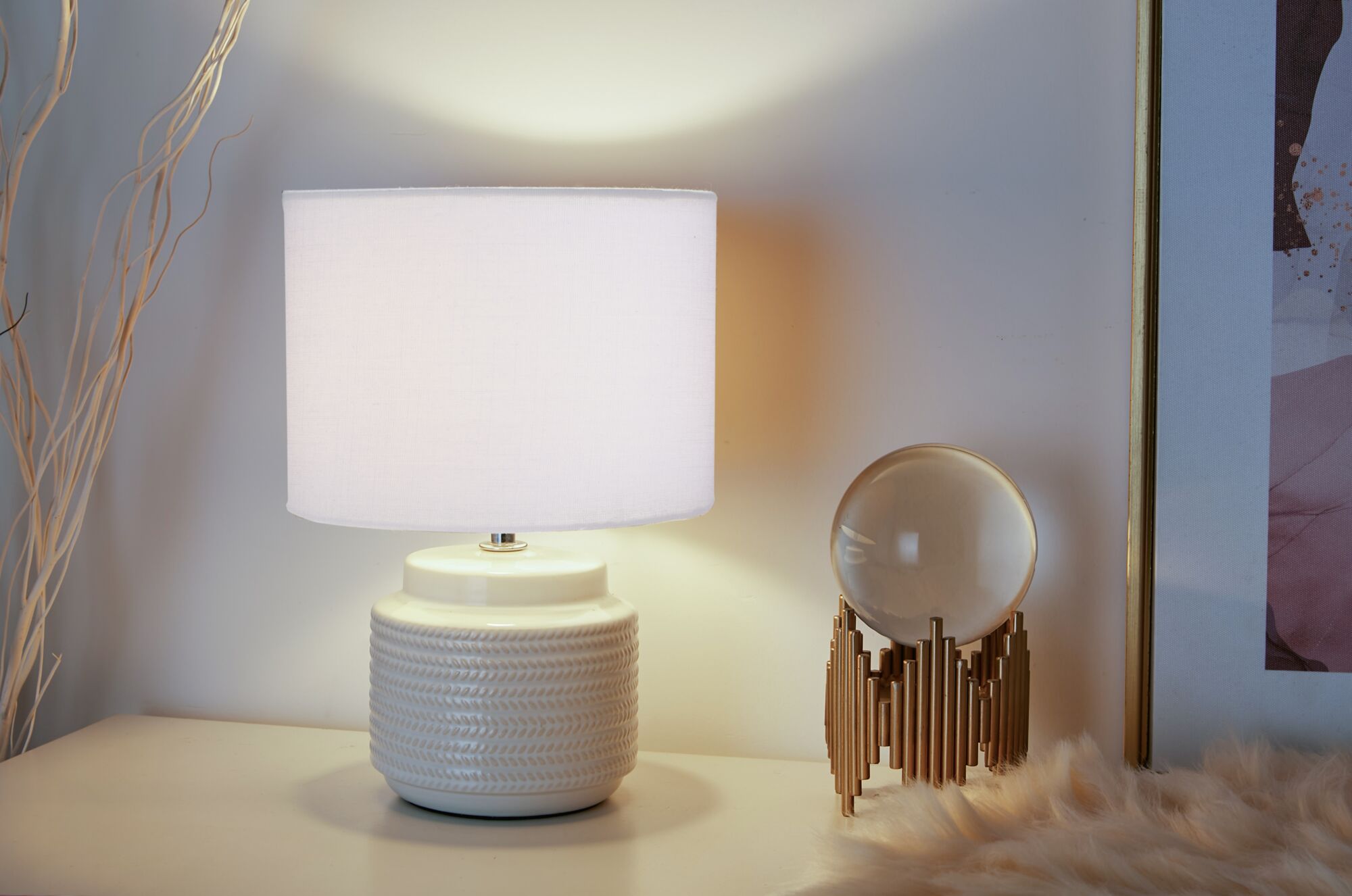 Lampe de table avec base en céramique crème et abat-jour en tissu beige pour une ambiance chaleureuse.
