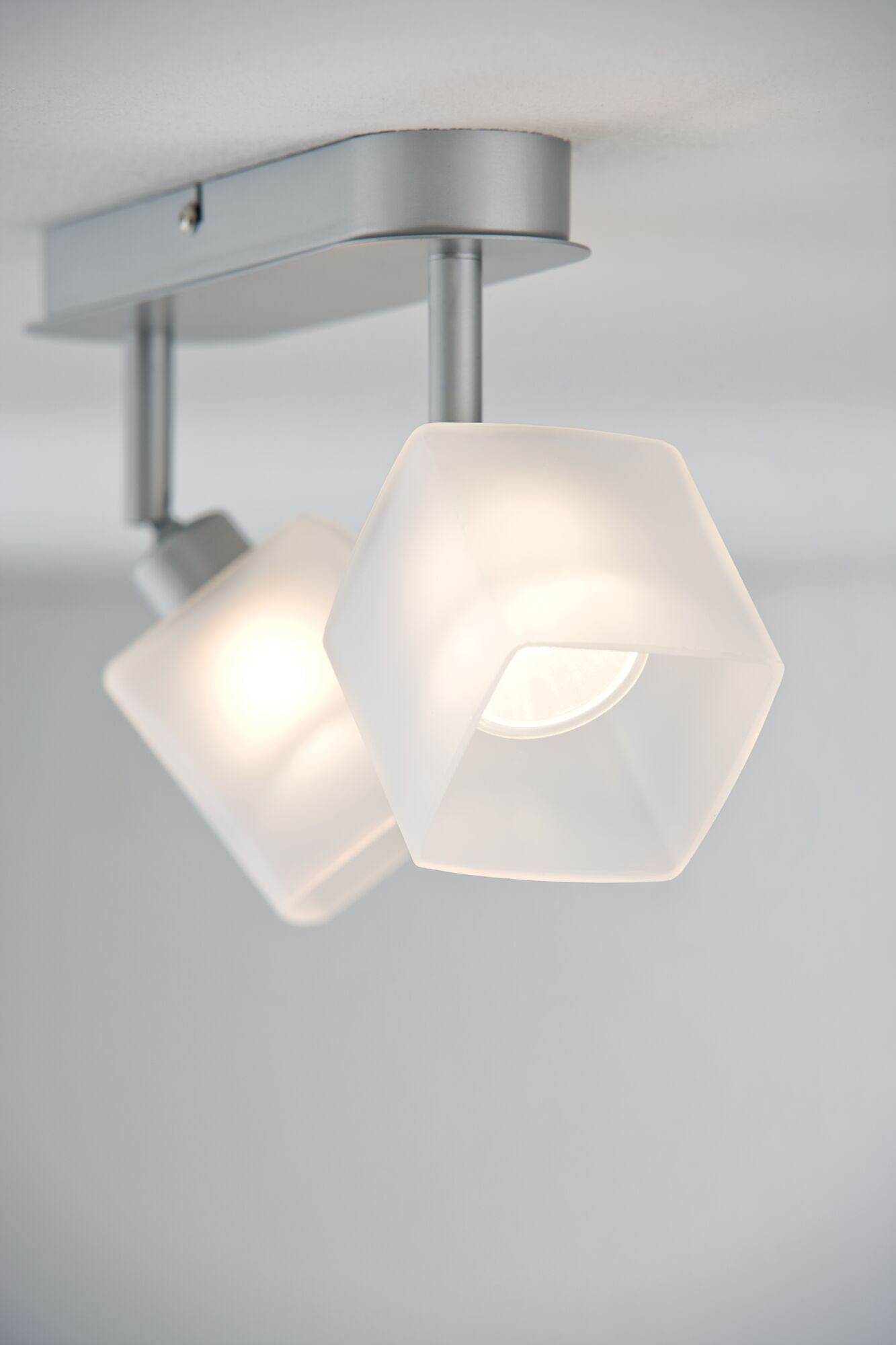 Modern ceiling light with two white glass shades and silver metal frame for living spaces