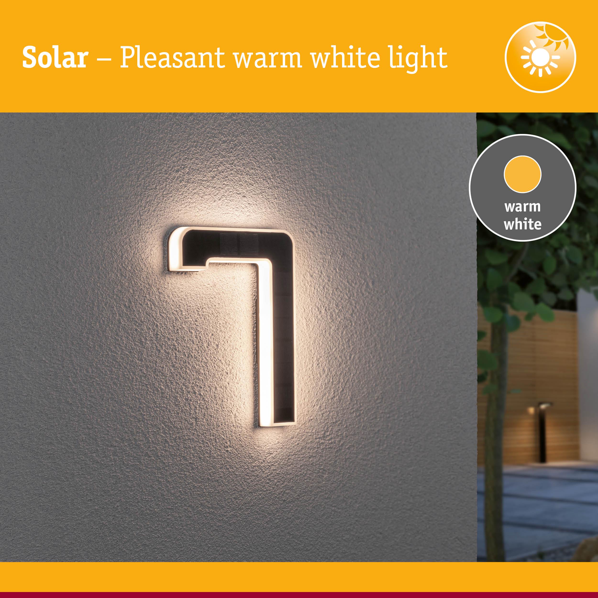 Solar-powered black LED wall light with warm white illumination for outdoor and garden lighting