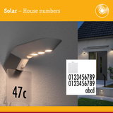 Solar-powered house number with LED light and black digits on white panel for outdoor lighting