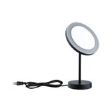 Black LED table mirror with round illuminated surface and power plug for makeup and cosmetic use.