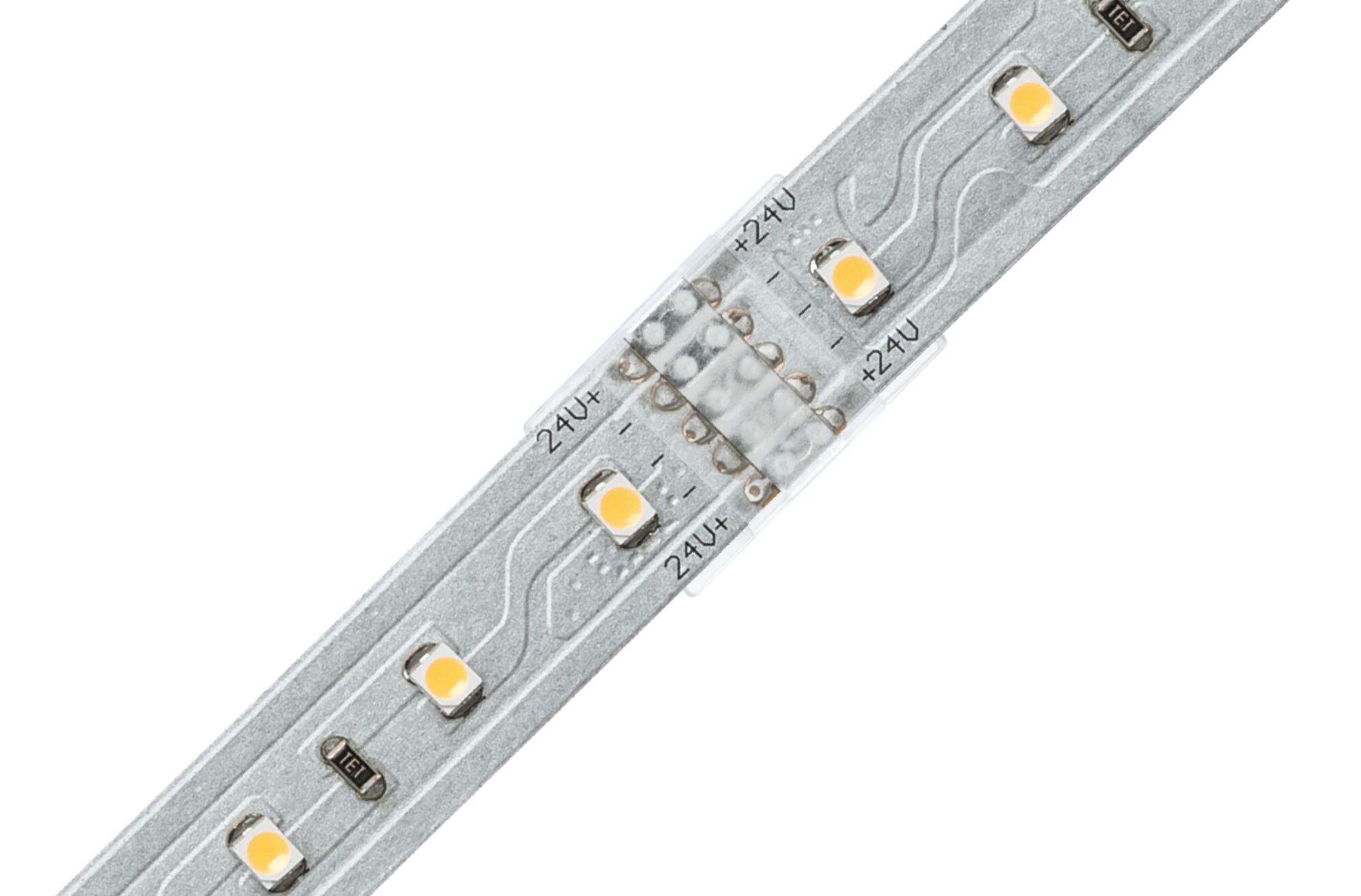 Nærbillede af sølvfarvet LED-strip med gule LED'er og 24V markeringer til belysning.