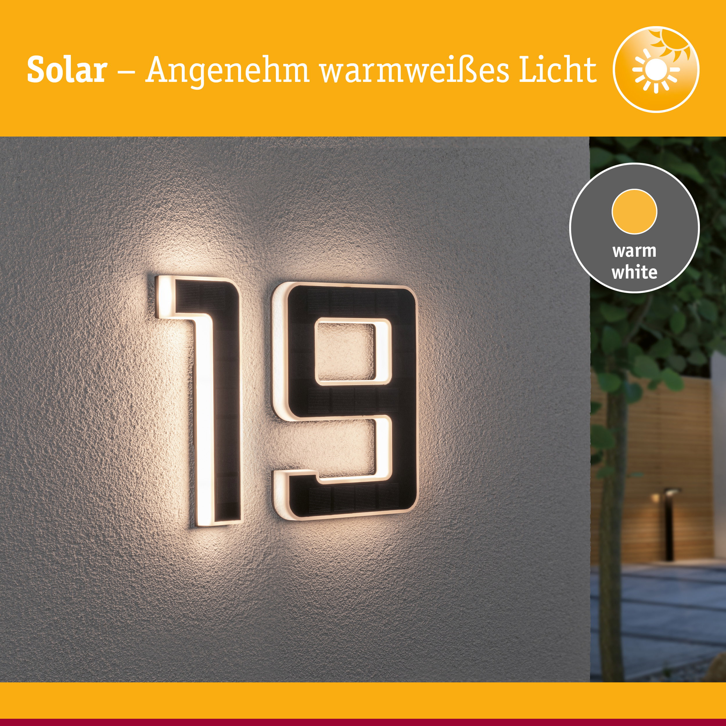 Solarhausnummer aus schwarzem Material mit warmweißem LED-Licht an grauer Wand beleuchtet