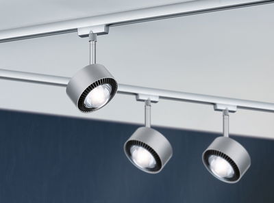 Drie zilverkleurige metalen LED-railspots gemonteerd aan wit plafond voor moderne verlichting