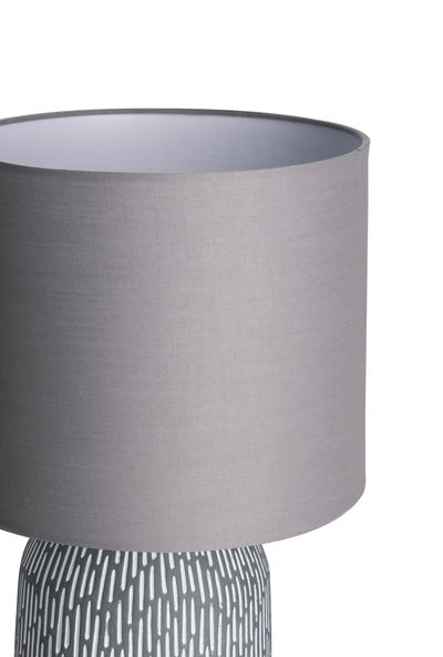 Table lamp with grey fabric shade and patterned white and grey ceramic base for living spaces.
