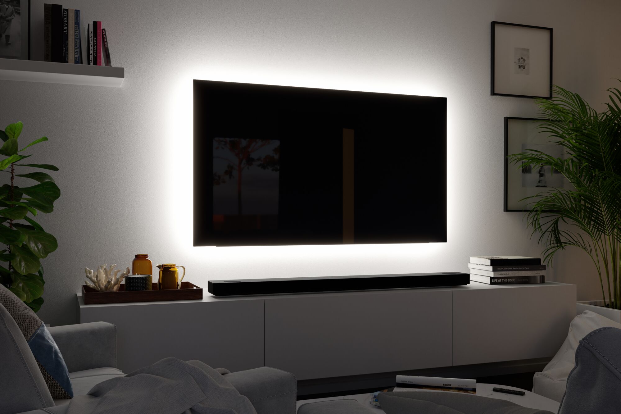 Schwarzer Fernseher mit weißem LED-Hintergrundlicht an weißer Wand im modernen Wohnzimmer
